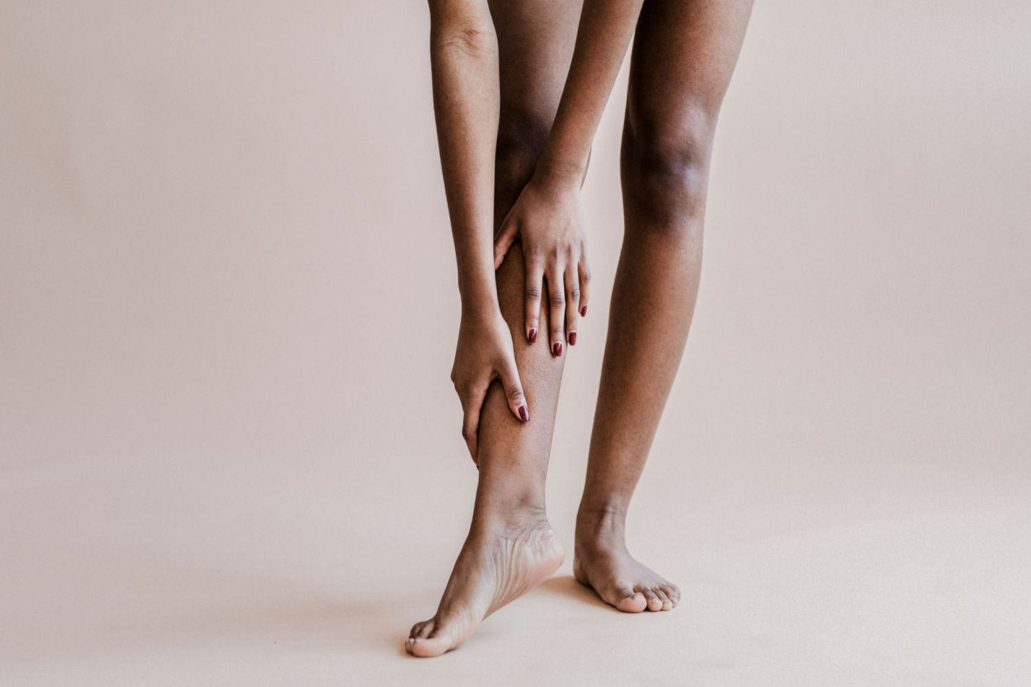 Black woman experiencing soreness and heaviness in her legs due to DVT