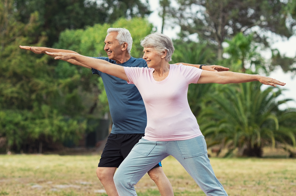 elderly couple practice yoga to improve heart health based on advice from cardiovascular experts in flint and lapeer michigan