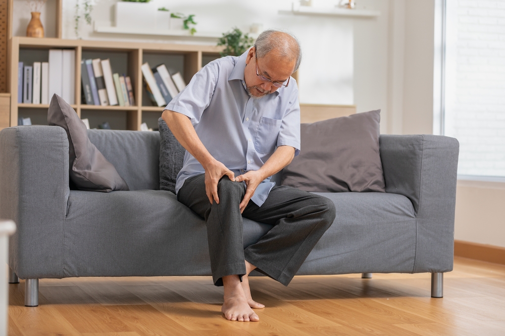 A man holding his leg in pain.